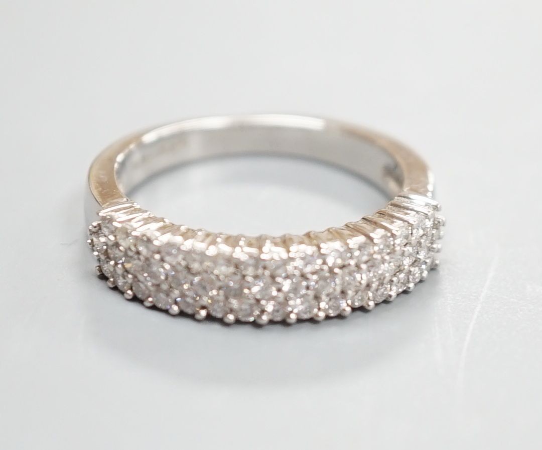 A modern 18ct white gold and three row diamond chip set half hoop ring, size K/L, gross weight 4.2 grams